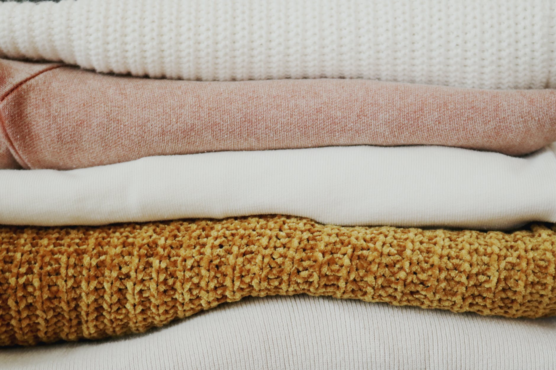 piled of folded textiles - Why I Quit My Capsule Wardrobe