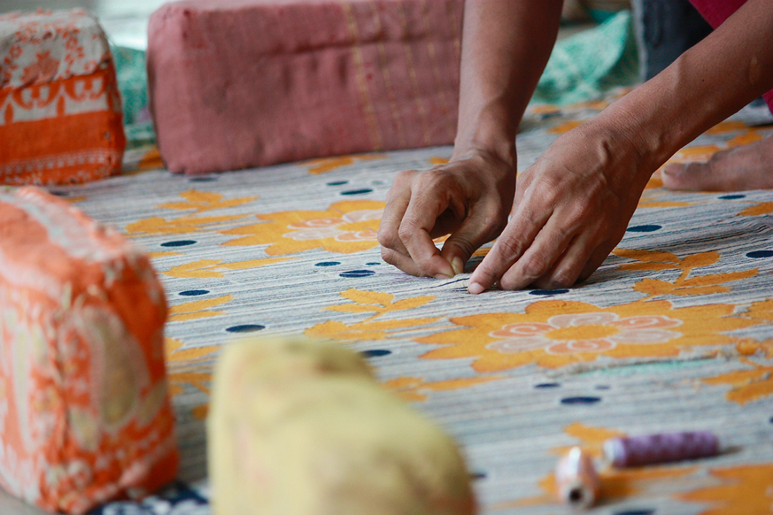 hands at work on a kantha quilt - A History of Kantha
