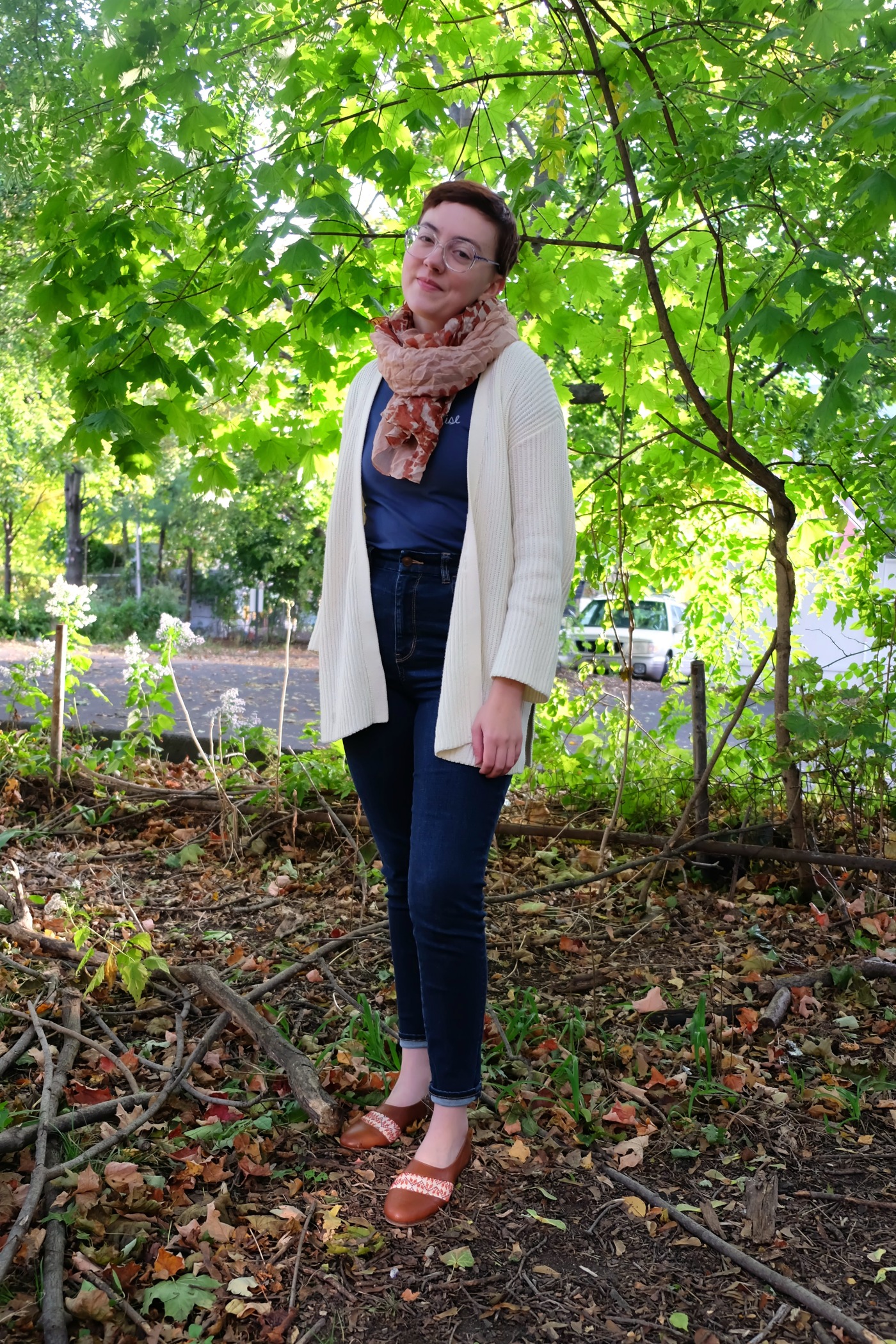 Leah stands with bright green flowers behind her wearing Darzah Tatreez Oxfords Styled for fall