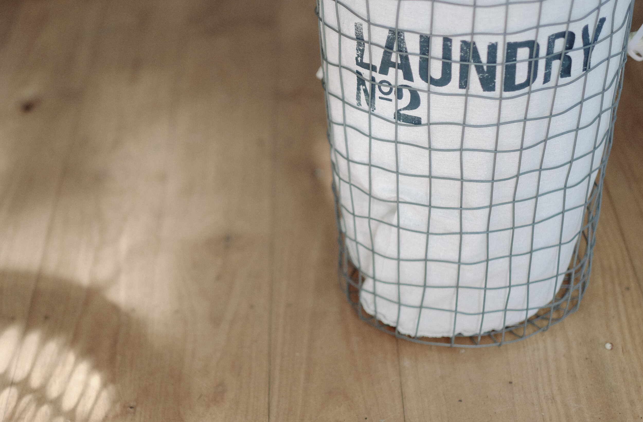 laundry basket on wood floor - Natural Laundering Tips