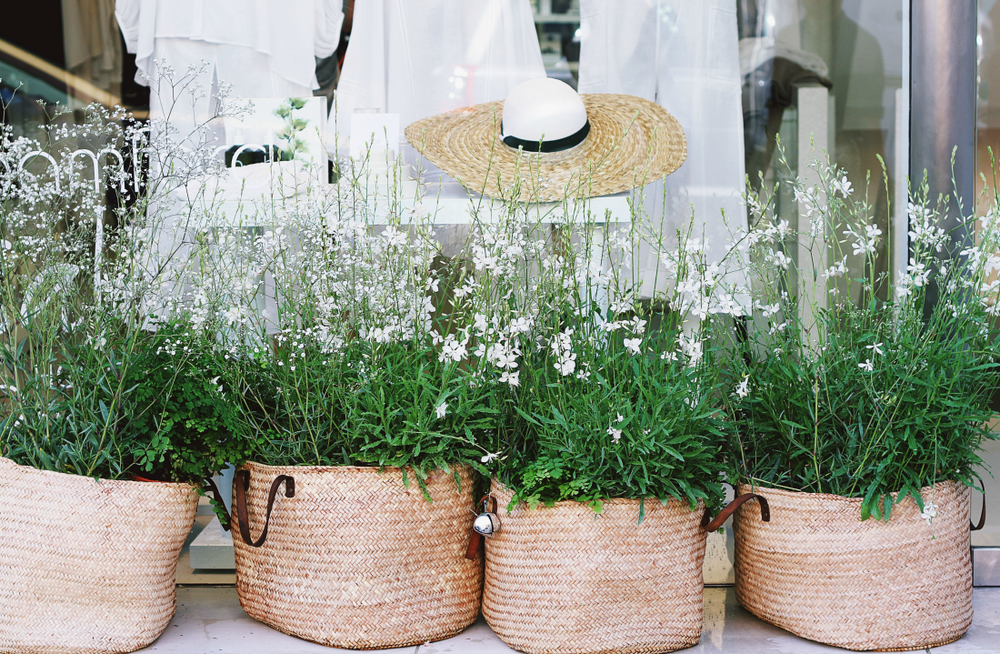 flowers in wicker baskets at a storefront - Ethical Purity in Sustainable Fashion