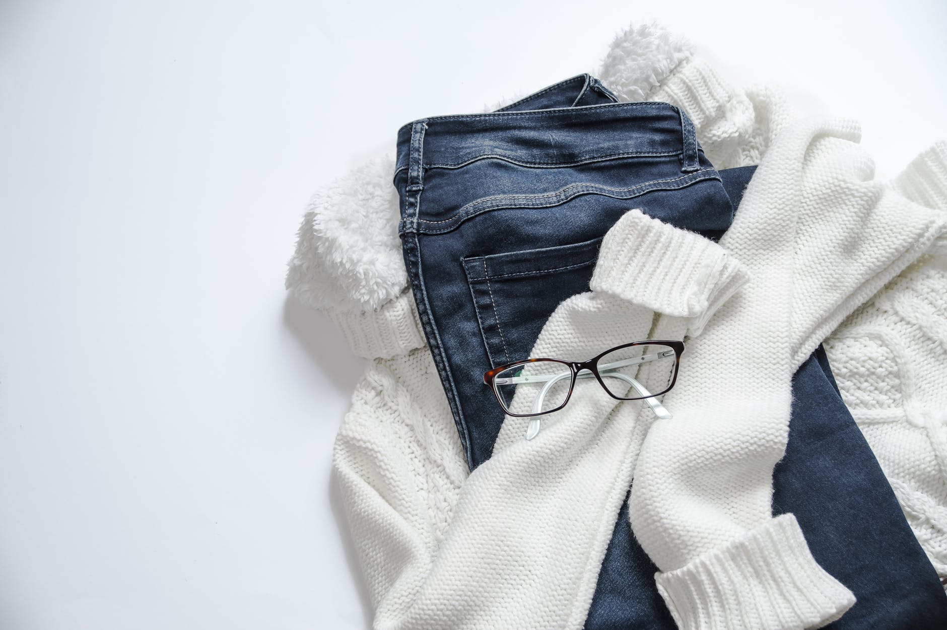 black framed eyeglasses on white jacket and blue denim bottoms - Sustainable Capsule Wardrobe Brands