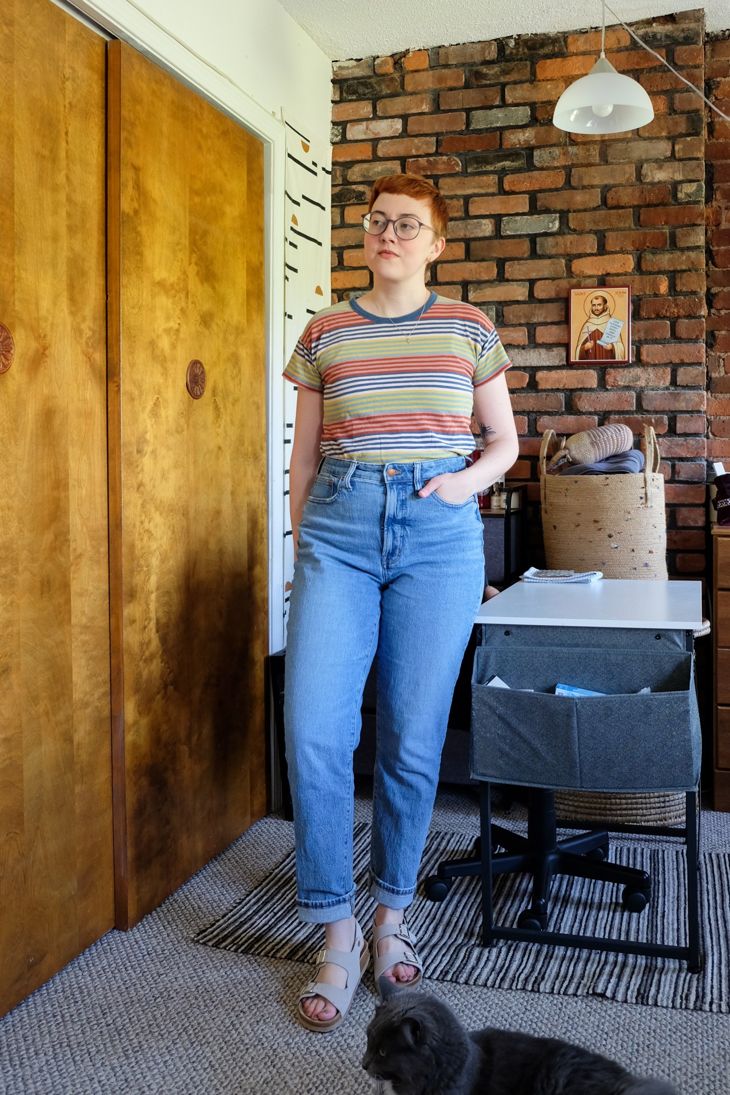 Leah stands in her bedroom wearing a striped shirt, light wash jeans, and sandals - Summer Favorites