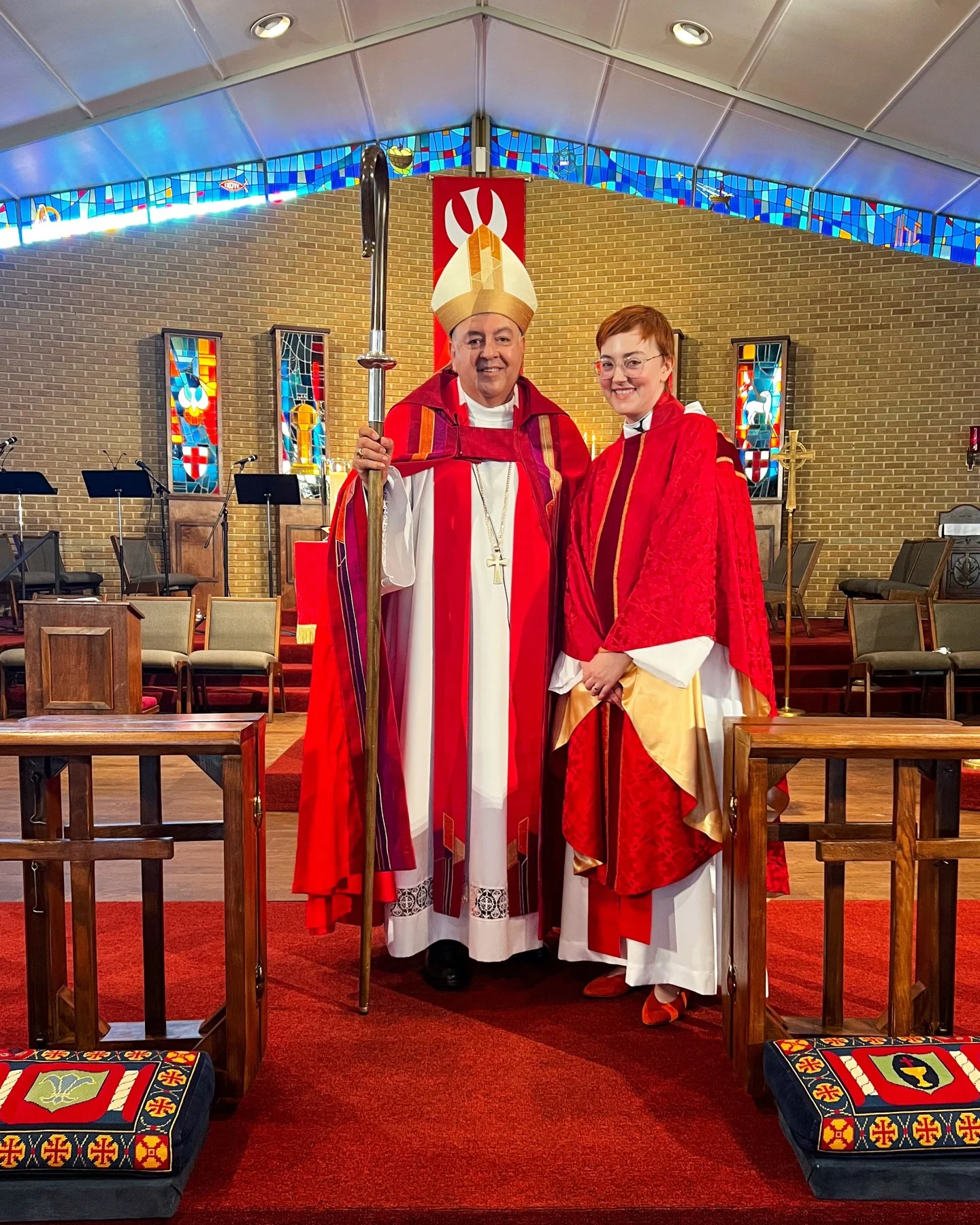Leah stands in full vestments next to bishop at ordination to the priesthood - 2023 word joy reflection