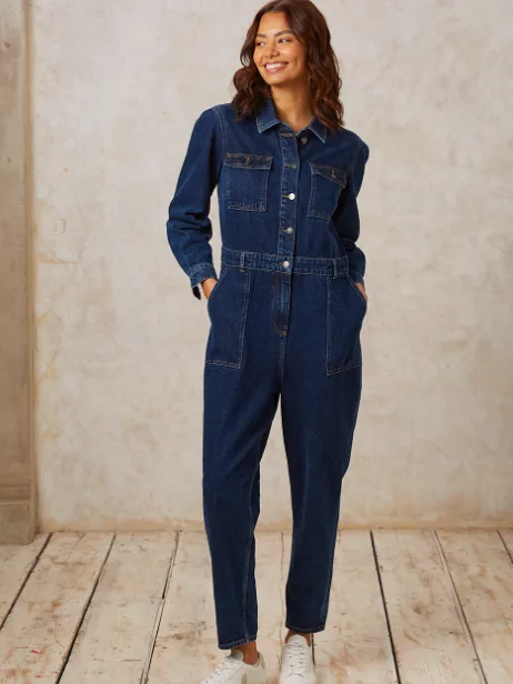 woman stands smiling wearing a denim jumpsuit - Zara ethical sustainable alternatives