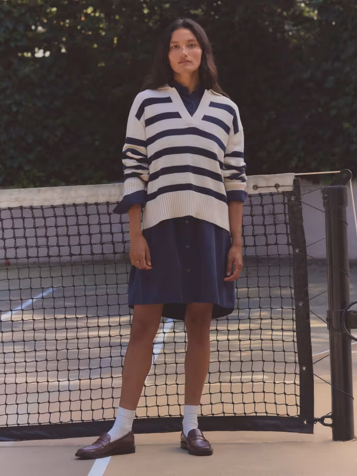 product shot from Everlane wearing striped sweater over navy shirt dress with socks and loafers